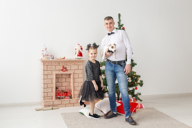 Feliz joven padre y su hija en casa con árbol de navidad Foto Premium