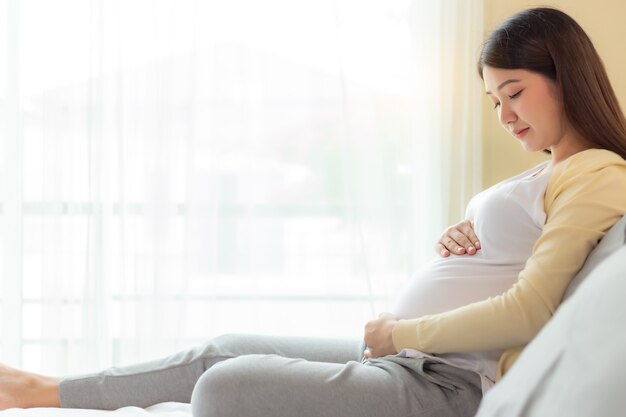 Feliz Madre Embarazada Tocando Y Mirando El Vientre Sentada En La Cama En El Dormitorio 2089