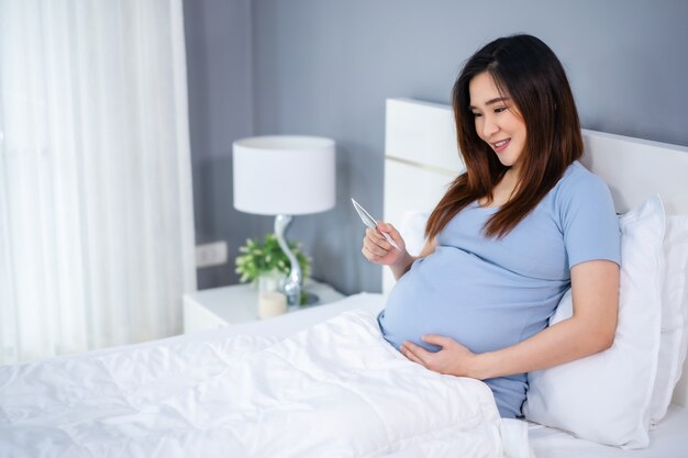 Feliz Mujer Embarazada Sosteniendo Y Mirando Foto De Ecografía En Una ...