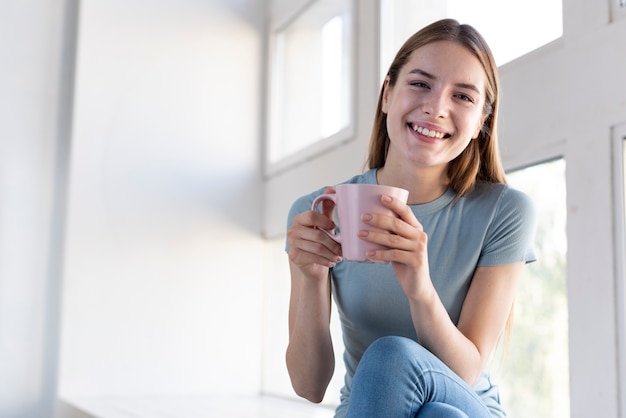 Feliz mujer sosteniendo una taza de café Foto gratis