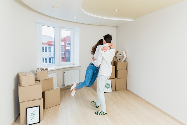 Feliz pareja amorosa con cajas de cartÃ³n en casa nueva en el dÃ­a de mudanza Foto gratis