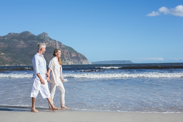 Feliz Pareja Caminando Descalzo En La Playa Foto Premium 