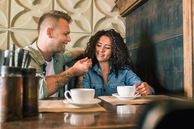 Feliz Pareja Joven Está Bebiendo Café Y Sonriendo Mientras Está Sentado En El Café Foto Gratis 6351