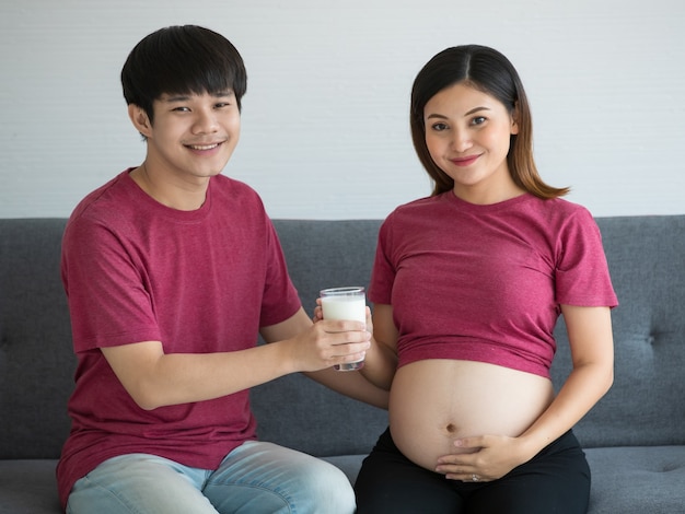 Feliz pareja joven hombre joven y mujer sentados juntos en un sofá un