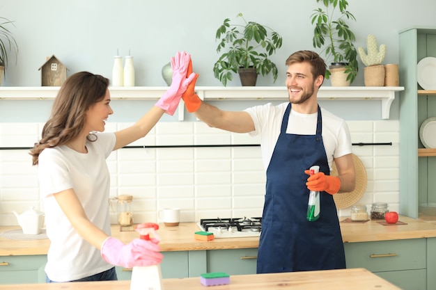 Feliz Pareja Joven Sonriendo Y Limpiando La Cocina Juntos Foto Premium 