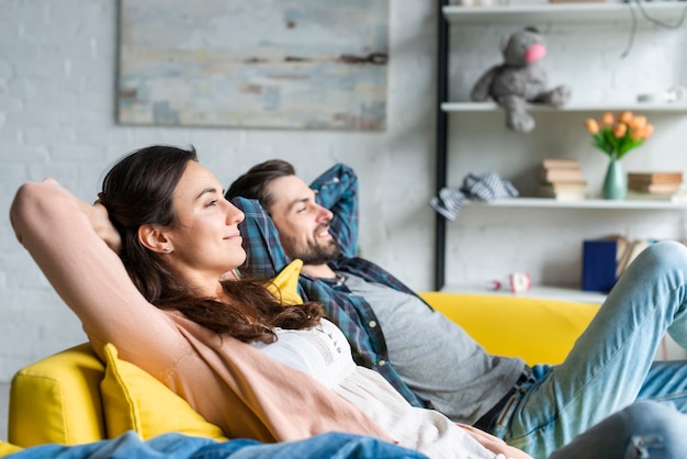 Feliz Pareja Sentada En El Sofá Foto Gratis 