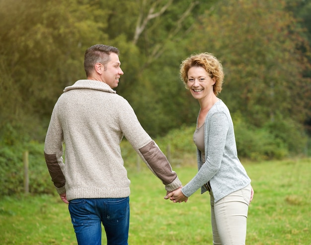 Feliz pareja tomados de la mano y caminando al aire libre | Foto Premium