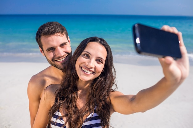 Feliz Pareja Tomando Un Selfie En La Playa Foto Premium