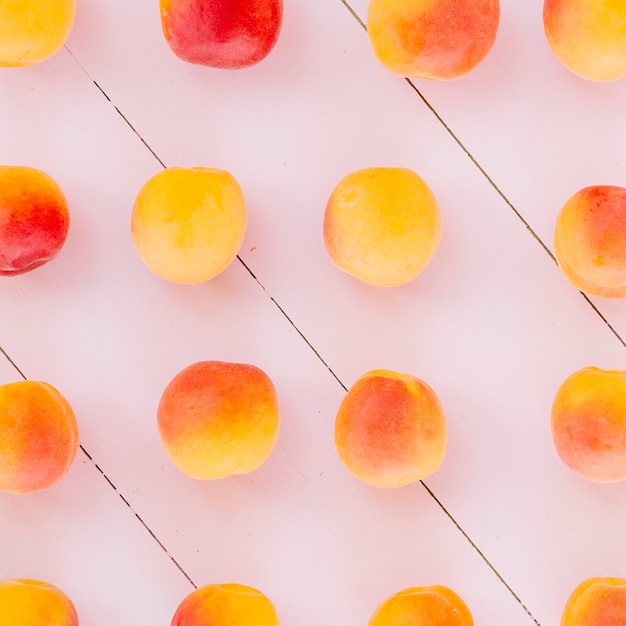 Fila de frutas de durazno en el fondo de madera Foto gratis