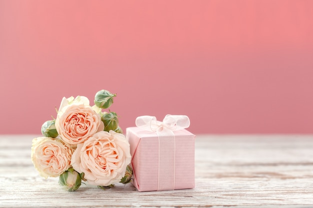 Flores de rosas rosadas y regalo o presente cuadro fondo rosa. Foto Premium