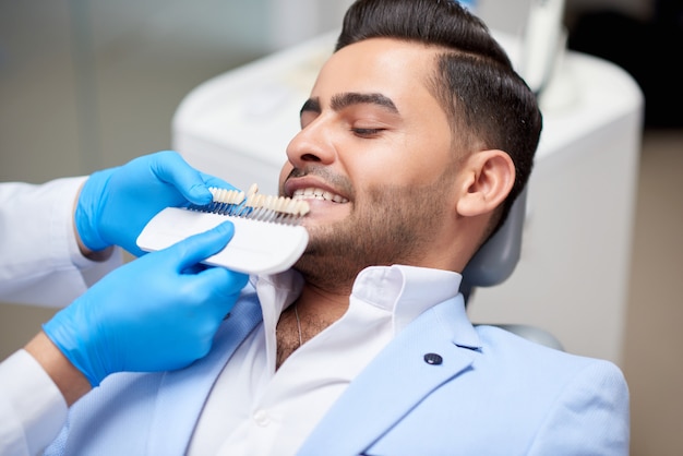 Foto de un apuesto joven en una cita médica en la oficina del dentista