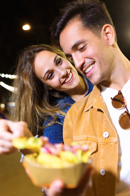 Foto De La Encantadora Pareja Atractiva Comiendo Patatas Juntos En El Mercado De Comer En La