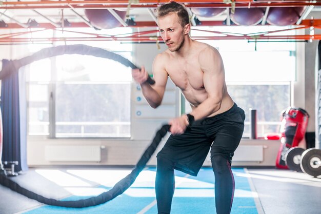 Foto De Hombre Poderoso Musculoso Entrenando Con Cuerda En El Gimnasio De Entrenamiento