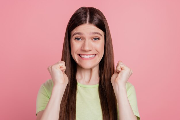 Foto de joven alegre feliz sonrisa positiva regocijo ganar victoria puños manos aisladas sobre