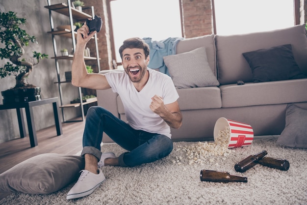 Foto De Raza Mixta árabe Chico Sentado En La Alfombra Cerca Del Sofá Mantenga El Joystick 6466