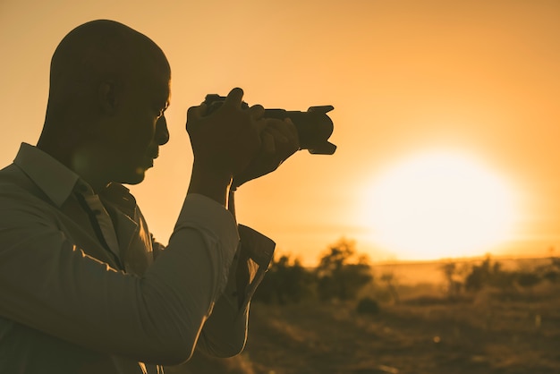 Fot Grafo Negro Tomando Fotos Al Atardecer Con Espacio De Copia Foto Premium