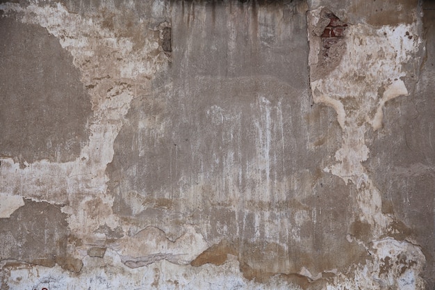 Fragmento de una vieja pared de ladrillos con yeso de hormigón y restos