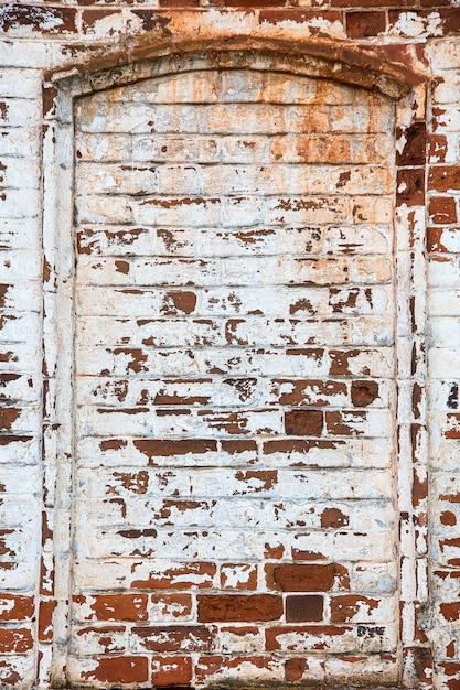 Fragmento de una vieja pared de ladrillos con yeso de hormigón y restos