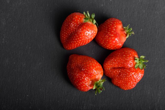 Fresas Organicas Frescas Aisladas En Una Pared Negra Entrega De Productos Naturales Envases Elaborados Con Fresas Organicas Foto Premium