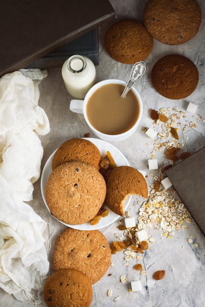 Galletas de avena, libros, copos de avena, taza de café