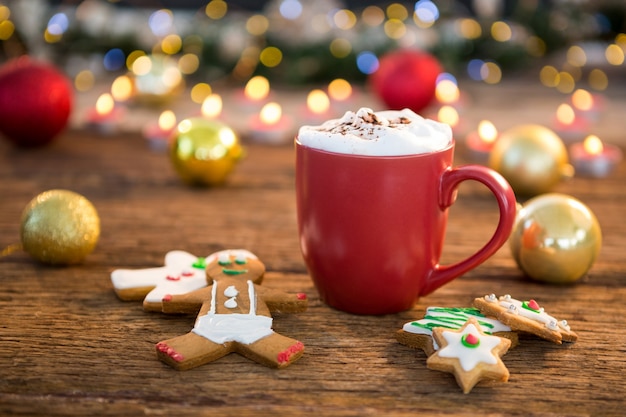 Galletas de navidad junto a una taza roja | Foto Gratis