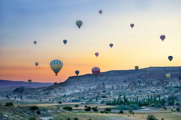 Globo aerostático volando sobre el paisaje de roca en capadocia turquía ...