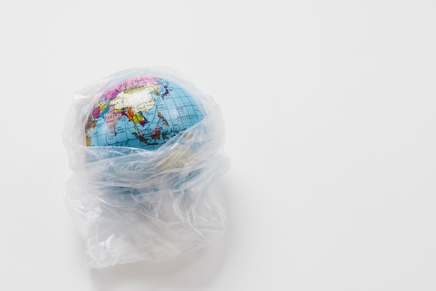 Globo terráqueo envuelto en bolsa de plástico basura Foto gratis