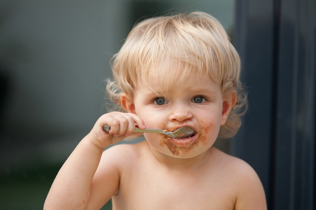 Gracioso Bebe Rubio Comiendo Chocolate Foto Premium