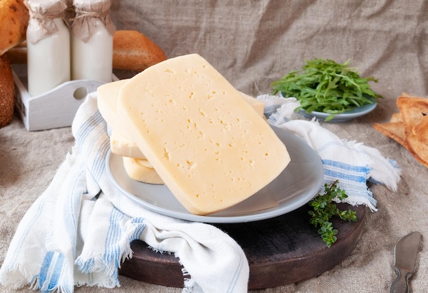 Un Gran Trozo De Queso Semiduro En Una Placa Gris Sobre Una Tabla De