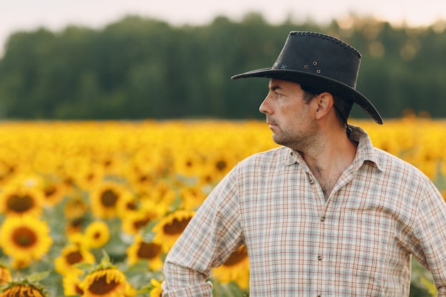 Granjero De Hombre De Pie En Un Campo De Girasoles Foto Premium