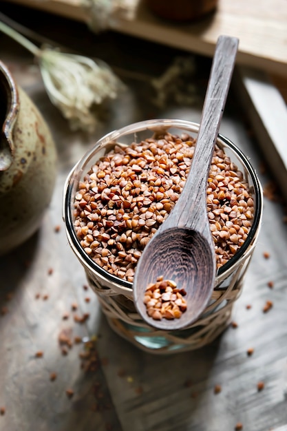 Grano de trigo sarraceno crudo orgánico sobre mesa de madera Foto Gratis