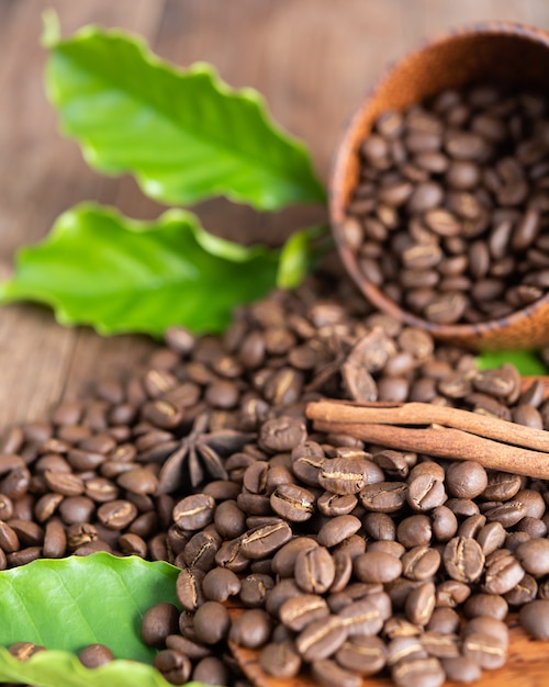 Granos de café tostados en un tazón de madera con canela