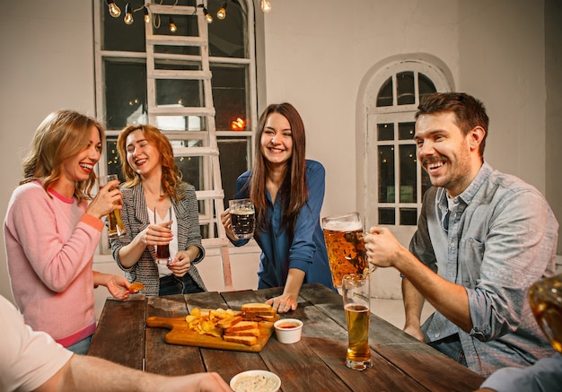 Grupo De Amigos Disfrutando De Bebidas Con Cerveza Por La Noche Foto Gratis