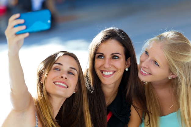 Grupo de amigos tomando selfie en la calle.  Descargar 