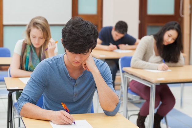 Grupo De Estudiantes Sentados Un Examen | Foto Premium