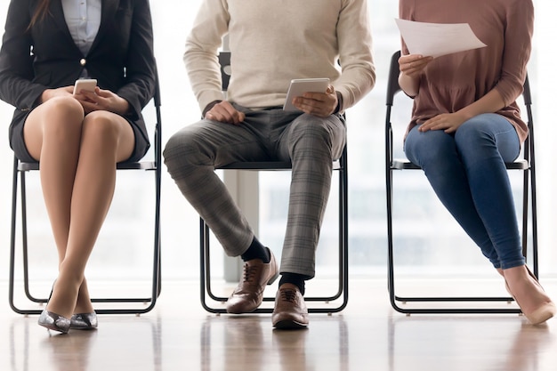 Grupo de personas esperando para una entrevista de trabajo, sentados en sillas Foto gratis