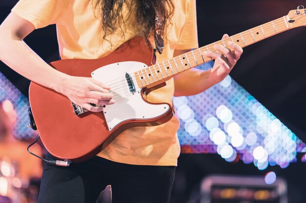 Guitarrista tocando la guitarra eléctrica en el escenario del concierto