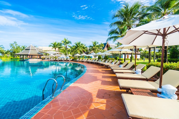 Hamacas y sombrillas puestas cercas de una piscina grande Foto gratis