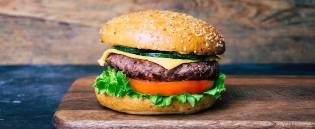 Hamburguesa casera (hamburguesa con queso) con carne sobre un fondo de madera. hamburguesa casera clásica. Foto Premium