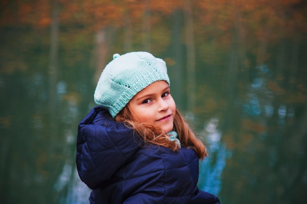 Hermosa chica con cabello largo y rubio en el parque de otoño chica de