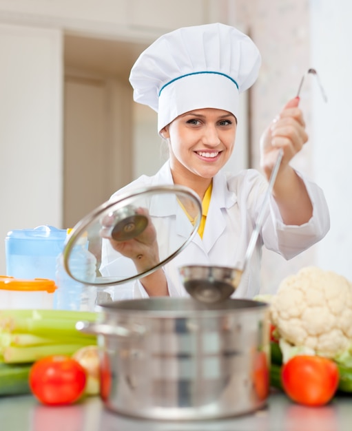 Hermosa cocinera en toque prepara almuerzo vegetariano Foto Gratis