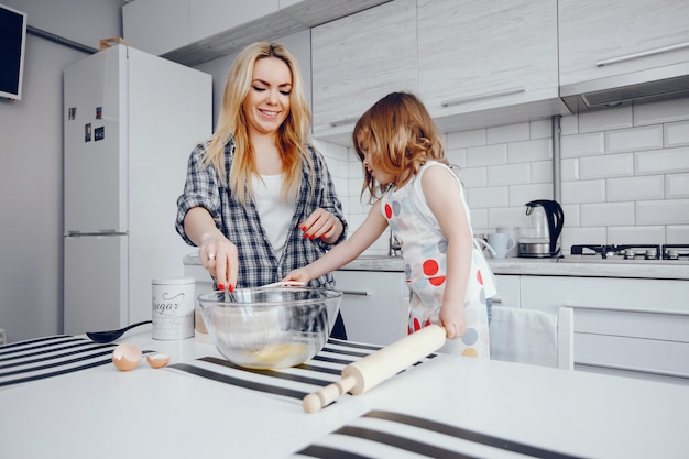 Una Hermosa Joven Madre Con Su Pequeña Hija Está Cocinando En La Cocina En Casa Foto Gratis 