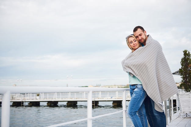 Hermosa Joven Pareja Abrazándose De Pie En Un Muelle Cerca Del Agua Foto Gratis 