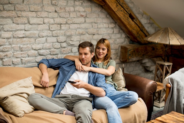 Hermosa Joven Pareja Viendo La Televisión En Casa Foto Premium