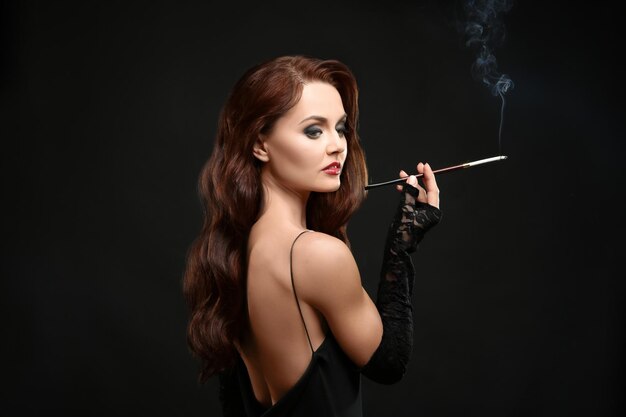 Hermosa Mujer Fumando Cigarro Sobre Fondo Oscuro Foto Premium