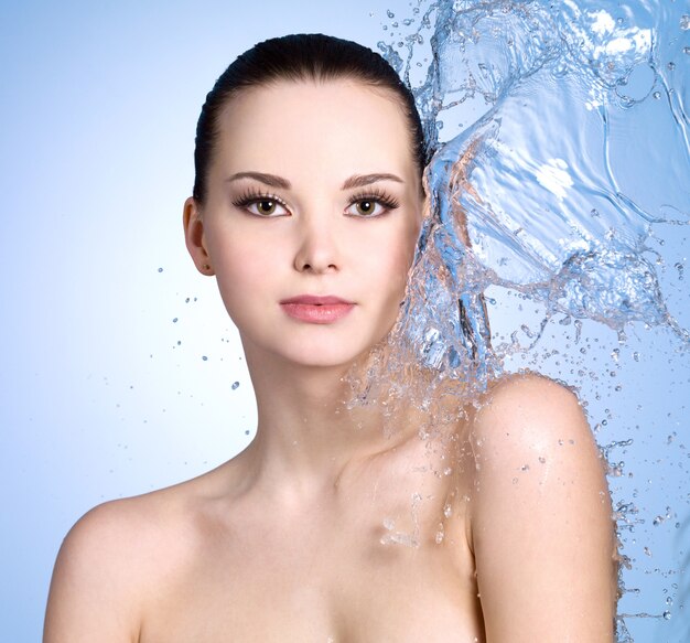 Hermosa Mujer Joven Con Salpicaduras De Agua En Su Espacio Del Color Del Cuerpo Foto Gratis