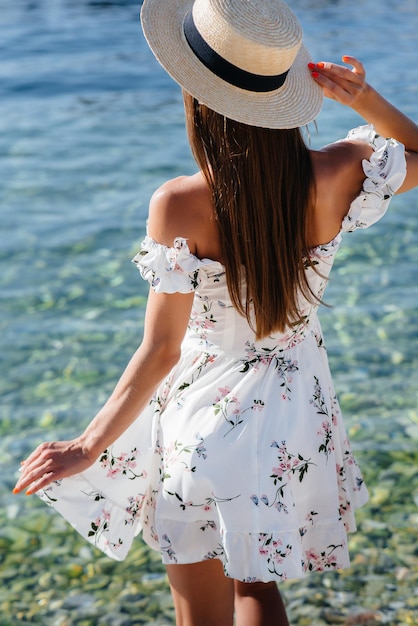 Una Hermosa Mujer Joven Con Un Sombrero Y Un Vestido Ligero De Espaldas