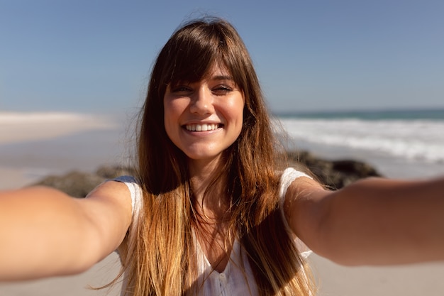 Hermosa Mujer Mirando A Cámara En La Playa Bajo El Sol Foto Gratis