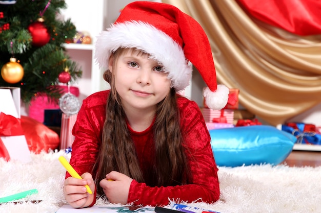 Hermosa Niña Escribe Una Carta A Santa Claus En Una Habitación Decorada De Forma Festiva Foto 