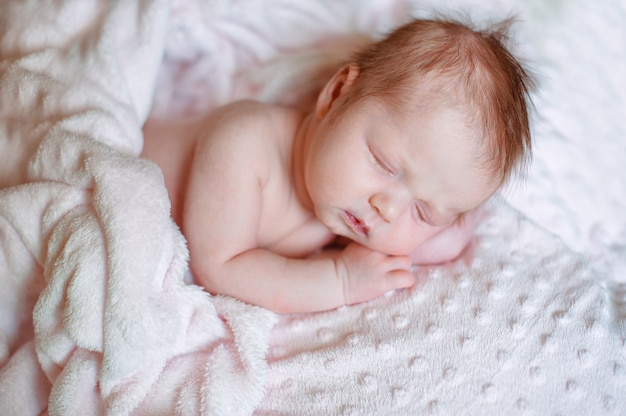 Hermosa niña recién nacida durmiendo en una manta rosa Foto Premium